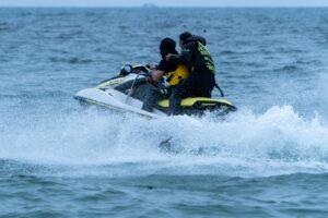 Two people enjoying a thrilling jet ski ride on the ocean. Perfect for adventure and water sports enthusiasts.